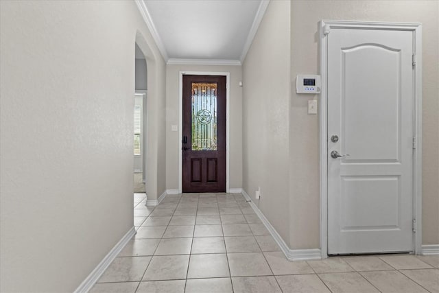 doorway featuring crown molding, arched walkways, baseboards, and light tile patterned floors
