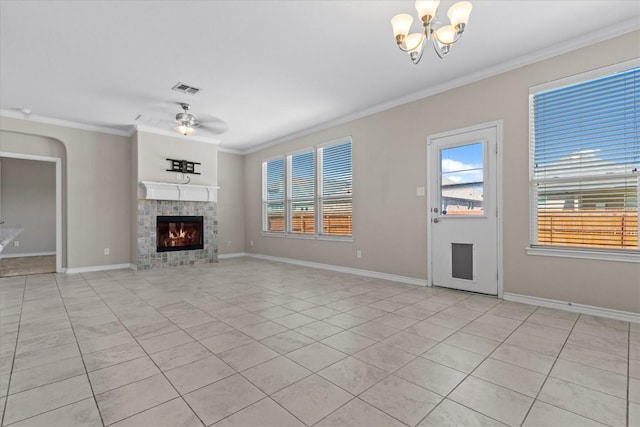 unfurnished living room with ornamental molding, a healthy amount of sunlight, a fireplace, ceiling fan with notable chandelier, and light tile patterned floors