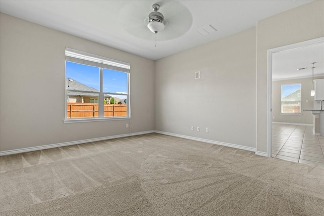 spare room featuring baseboards, a ceiling fan, carpet flooring, and visible vents