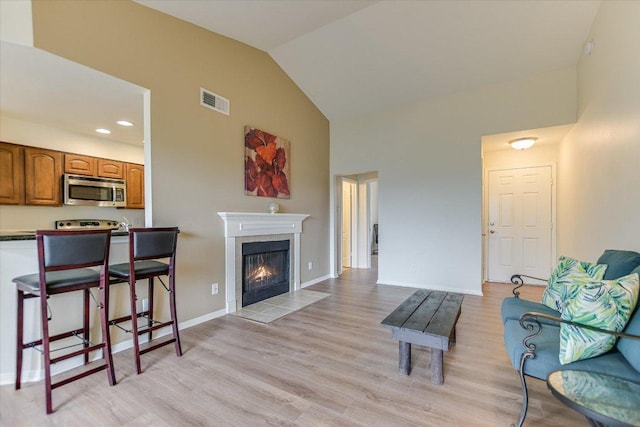6000 Shepherd Mountain Cv Unit 2007, Austin, TX 78730 - living area featuring light wood-style floors, a tile fireplace, high vaulted ceiling, baseboards, and recessed lighting
