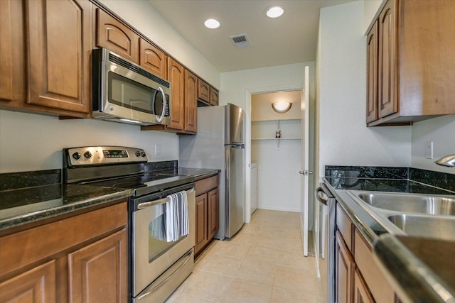 6000 Shepherd Mountain Cv Unit 2007, Austin, TX 78730 - kitchen with appliances with stainless steel finishes, brown cabinetry, dark stone countertops, a sink, and recessed lighting