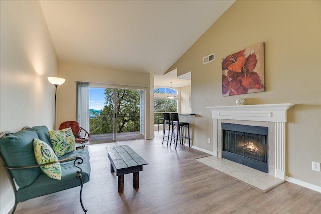 6000 Shepherd Mountain Cv Unit 2007, Austin, TX 78730 - living area with wood finished floors, high vaulted ceiling, a tiled fireplace, and baseboards
