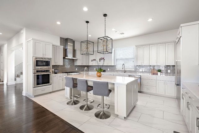 1304 High Lonesome, Leander, TX 78641 - kitchen featuring stainless steel appliances, wall chimney exhaust hood, a sink, a kitchen island with sink, and light countertops