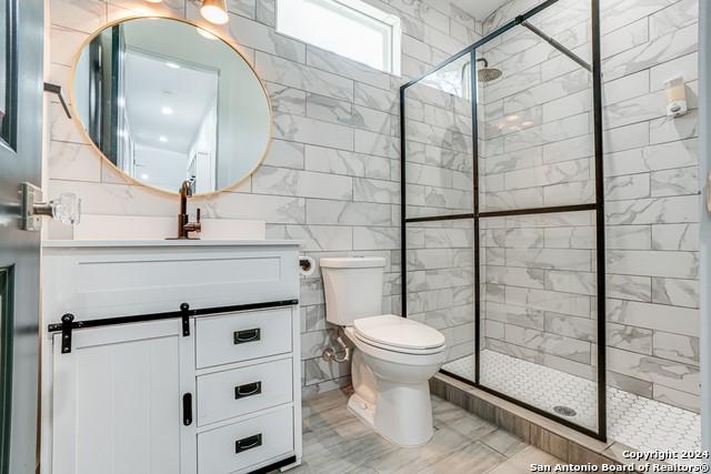 2540 Tanglewood Trl, Spring Branch, TX 78070 - bathroom featuring toilet, tile walls, a shower stall, and vanity