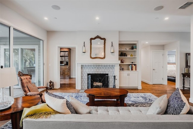 4801 Balcones Dr, Austin, TX 78731 - living area with light wood finished floors, a tiled fireplace, recessed lighting, and baseboards
