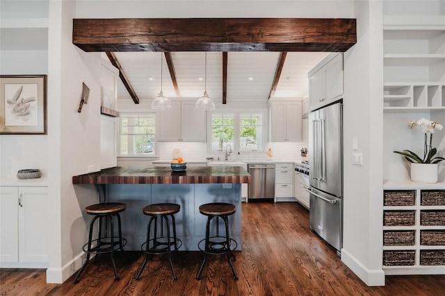 4801 Balcones Dr, Austin, TX 78731 - kitchen with appliances with stainless steel finishes, a sink, a peninsula, a breakfast bar area, and backsplash