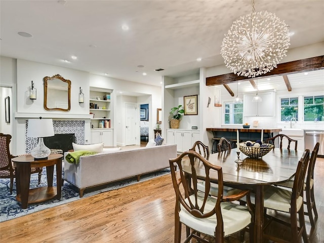 4801 Balcones Dr, Austin, TX 78731 - dining area with wood finished floors, recessed lighting, beam ceiling, a tiled fireplace, and a chandelier