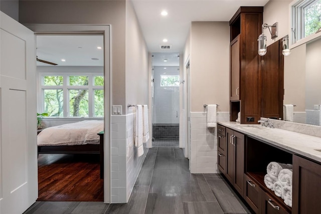 4801 Balcones Dr, Austin, TX 78731 - bathroom featuring vanity, a shower stall, wood finished floors, recessed lighting, and wainscoting