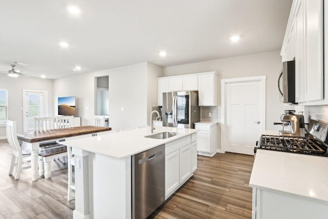 1208 Tipton St, Georgetown, TX 78633 - kitchen featuring appliances with stainless steel finishes, wood finished floors, a kitchen island with sink, white cabinets, and recessed lighting