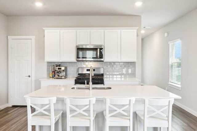 1208 Tipton St, Georgetown, TX 78633 - kitchen featuring appliances with stainless steel finishes, decorative backsplash, dark wood-style floors, and recessed lighting