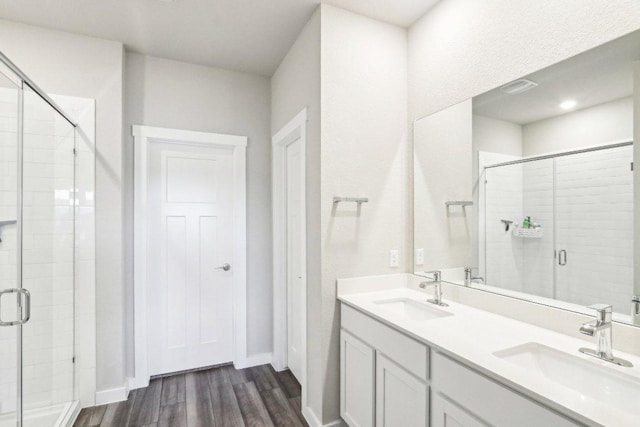 1208 Tipton St, Georgetown, TX 78633 - bathroom featuring wood finished floors, a stall shower, double vanity, and baseboards