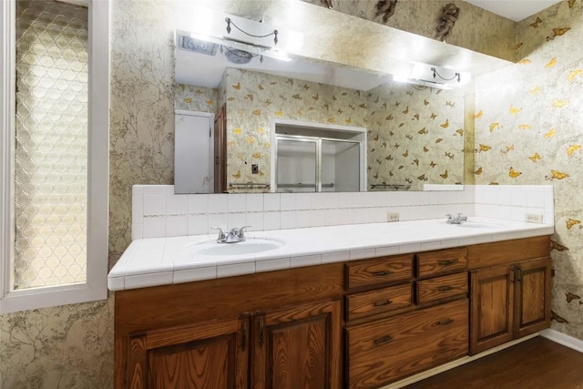 1402 Brown St, San Marcos, TX 78666 - full bath with a sink, double vanity, a stall shower, and wood finished floors