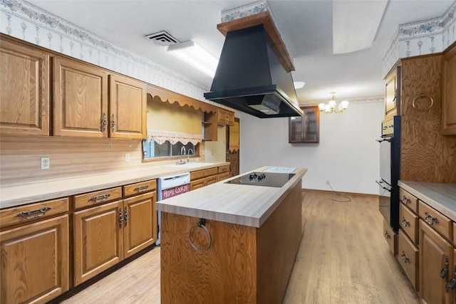 1402 Brown St, San Marcos, TX 78666 - kitchen featuring brown cabinetry, visible vents, island range hood, light wood finished floors, and black electric stovetop