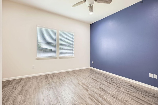 empty room with baseboards, ceiling fan, and wood finished floors