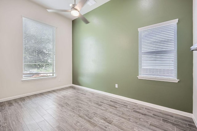 spare room featuring baseboards, ceiling fan, and wood finished floors
