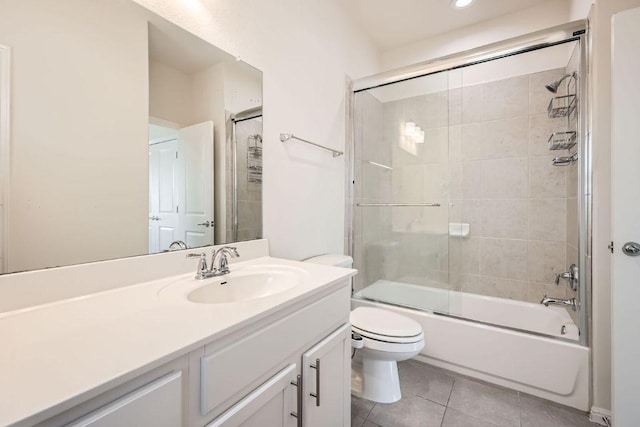 full bath with vanity, bath / shower combo with glass door, tile patterned floors, and toilet