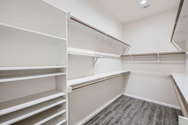 spacious closet featuring visible vents and dark wood-style floors