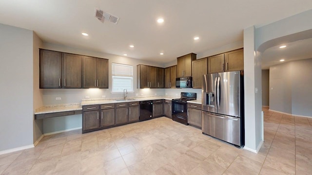387 Gustaf Trl, Kyle, TX 78640 - kitchen with black appliances, light countertops, dark brown cabinets, recessed lighting, and light tile patterned flooring