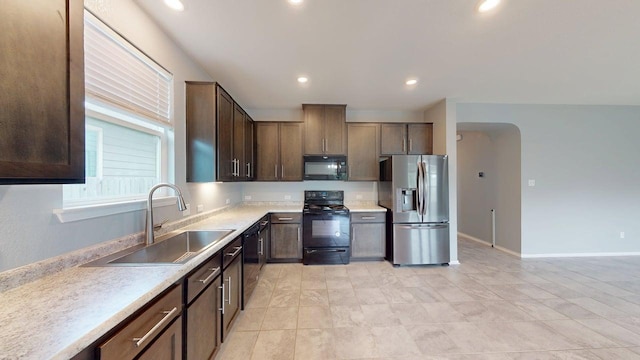 387 Gustaf Trl, Kyle, TX 78640 - kitchen featuring black appliances, light countertops, dark brown cabinets, recessed lighting, and arched walkways