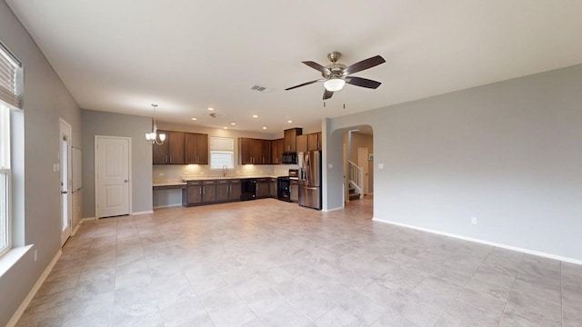 387 Gustaf Trl, Kyle, TX 78640 - kitchen featuring stainless steel fridge with ice dispenser, black microwave, light countertops, arched walkways, and stove