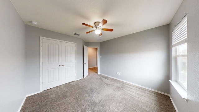 387 Gustaf Trl, Kyle, TX 78640 - unfurnished bedroom featuring carpet, a closet, and a ceiling fan