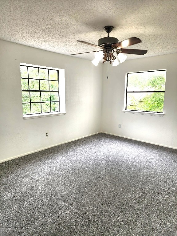 carpeted empty room featuring ceiling fan and a textured ceiling