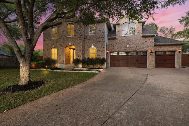 3109 Brigham Ct, Austin, TX 78732 - traditional-style home with a lawn, fence, brick siding, an attached garage, and driveway