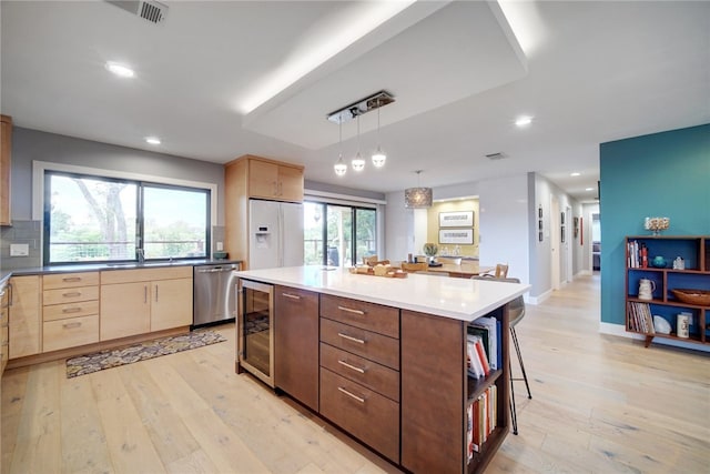4411 Bilboa Dr, Austin, TX 78759 - kitchen featuring stainless steel dishwasher, white fridge with ice dispenser, beverage cooler, light wood-style flooring, and light brown cabinetry