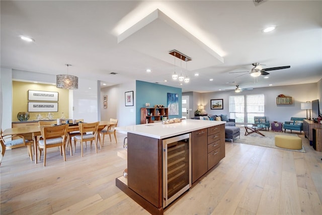4411 Bilboa Dr, Austin, TX 78759 - kitchen with beverage cooler, open floor plan, a ceiling fan, light wood-style flooring, and decorative light fixtures