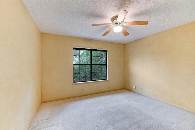 carpeted spare room with a ceiling fan, a textured ceiling, and baseboards