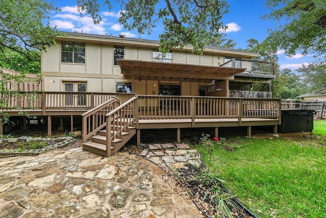 back of property with fence, a wooden deck, and stucco siding