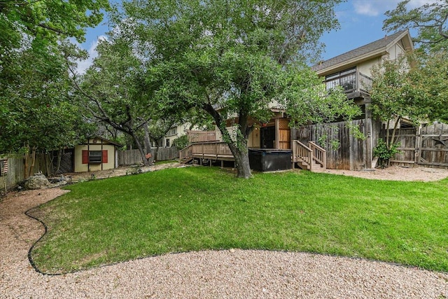 view of yard featuring an outdoor structure, a wooden deck, a fenced backyard, and a storage unit