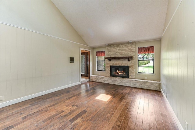 unfurnished living room with high vaulted ceiling, a fireplace, and dark wood-style flooring