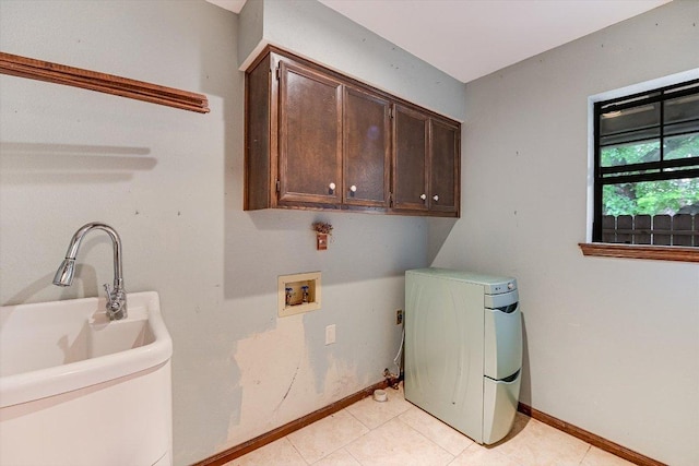 washroom with light tile patterned floors, baseboards, hookup for a washing machine, and cabinet space