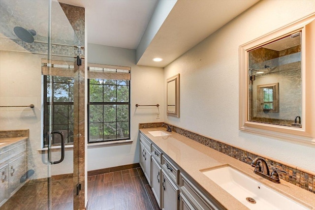 bathroom featuring double vanity, a sink, a stall shower, and recessed lighting