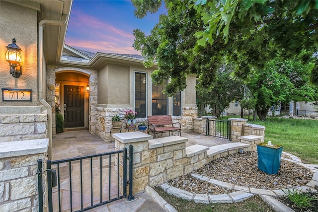 712 Independence Creek Ln, Georgetown, TX 78633 - property entrance featuring stucco siding, covered porch, and stone siding