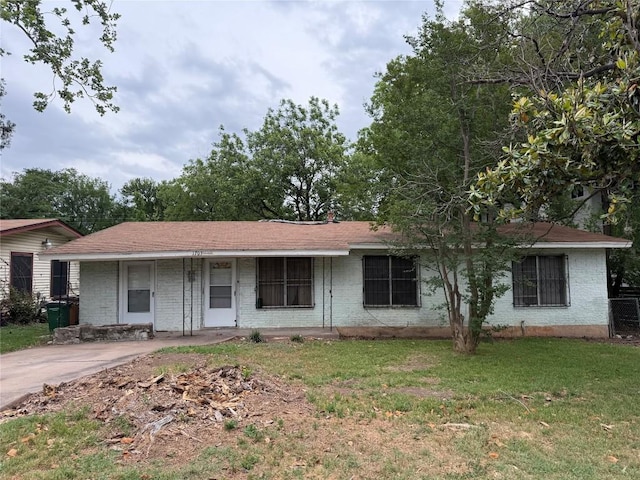 ranch-style home with a porch, brick siding, and a front yard