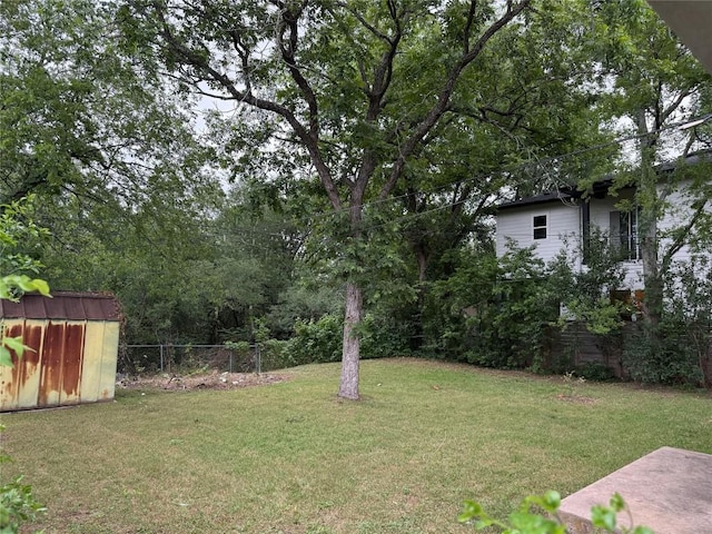 view of yard with a storage shed, fence, and an outdoor structure