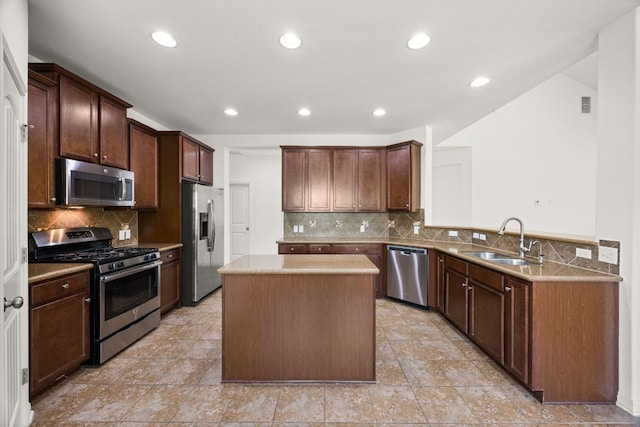 kitchen with decorative backsplash, a kitchen island, appliances with stainless steel finishes, a sink, and recessed lighting