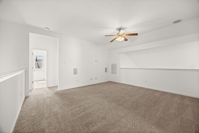 carpeted spare room featuring baseboards, a ceiling fan, and visible vents