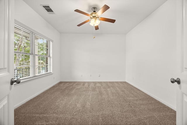 empty room featuring baseboards, visible vents, a ceiling fan, and light colored carpet