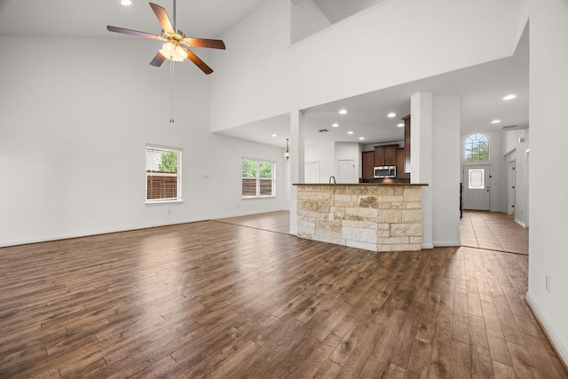 unfurnished living room featuring a ceiling fan, recessed lighting, plenty of natural light, and wood finished floors