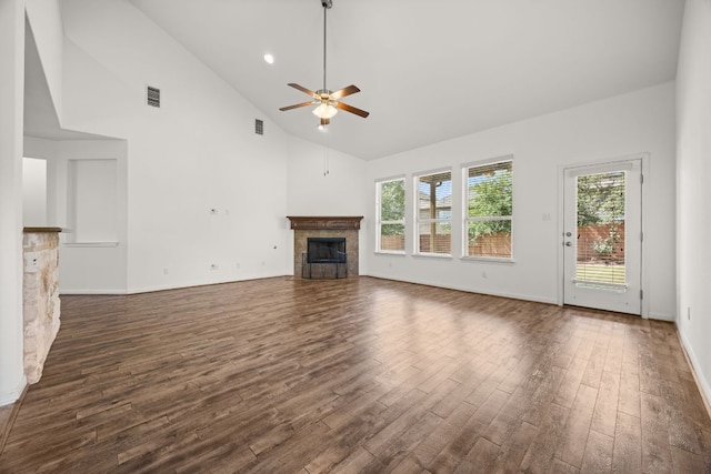 unfurnished living room with visible vents, a fireplace, high vaulted ceiling, a ceiling fan, and dark wood finished floors