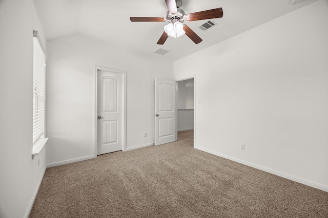 unfurnished bedroom featuring carpet floors, visible vents, baseboards, ceiling fan, and vaulted ceiling