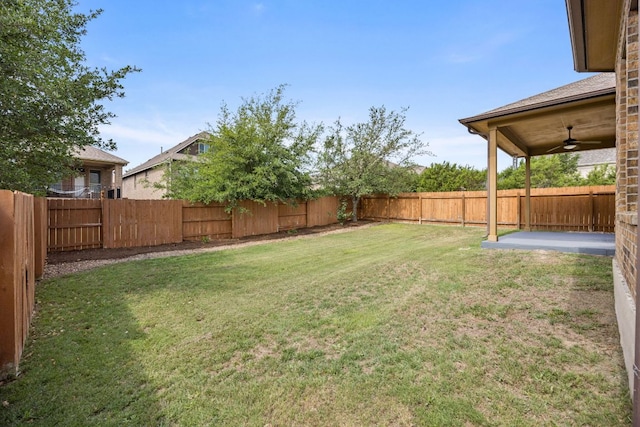 view of yard with a fenced backyard and a ceiling fan