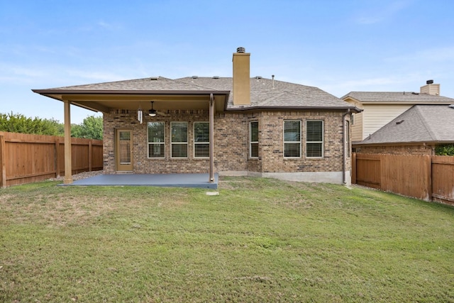 rear view of property with a fenced backyard, a patio area, and brick siding