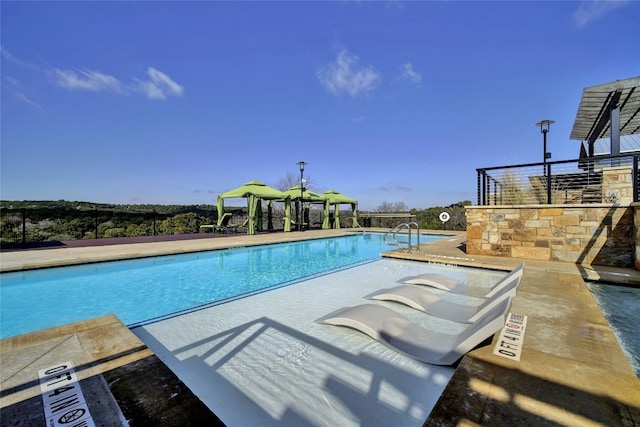community pool with a gazebo and a patio area