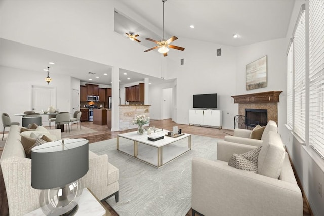 5929 Gunnison Turn Rd, Austin, TX 78738 - living area featuring lofted ceiling, a tile fireplace, a ceiling fan, light wood-type flooring, and recessed lighting