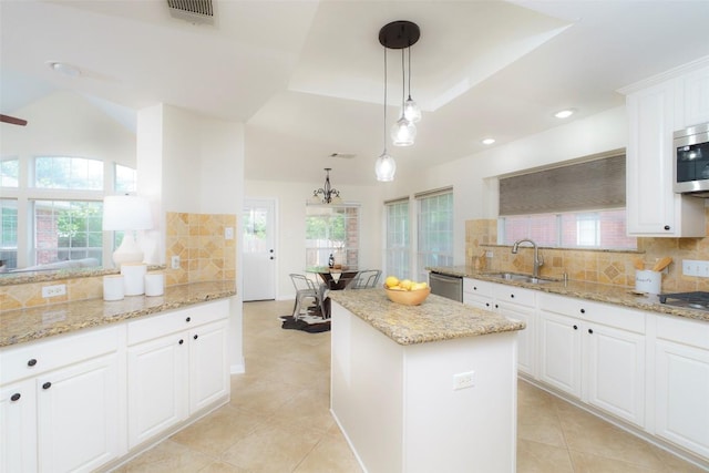 kitchen with visible vents, decorative backsplash, light tile patterned flooring, a center island, and a sink