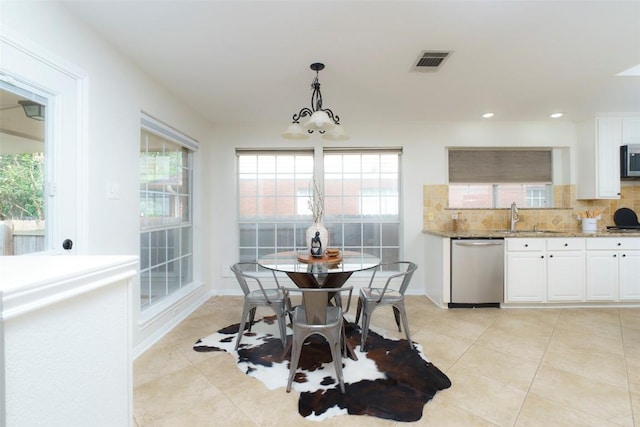 dining area with light tile patterned floors, plenty of natural light, and visible vents